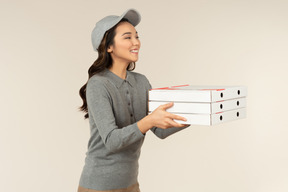 Jeune fille de livraison de pizza asiatique tenant des boîtes à pizza