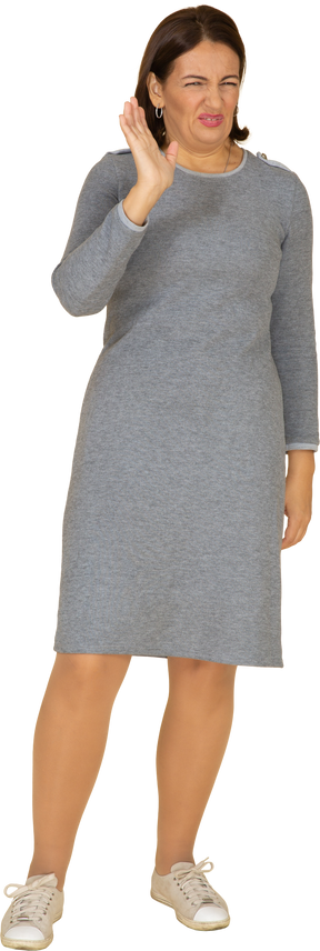 Front view of a woman in grey dress making faces