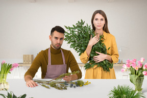 A man and a woman standing behind a table with flowers