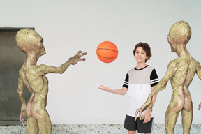 Aliens playing basketball with a boy