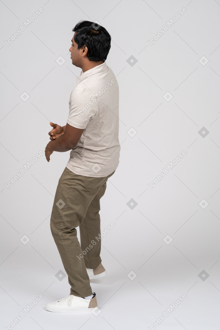 一个穿着白衬衫的站立男人的侧视图