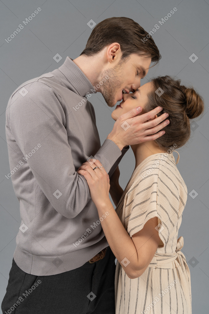 Young man biting his girlfriend's nose