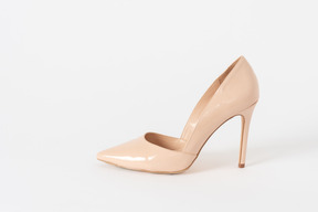 A side shot of a beige lacquered stiletto shoe