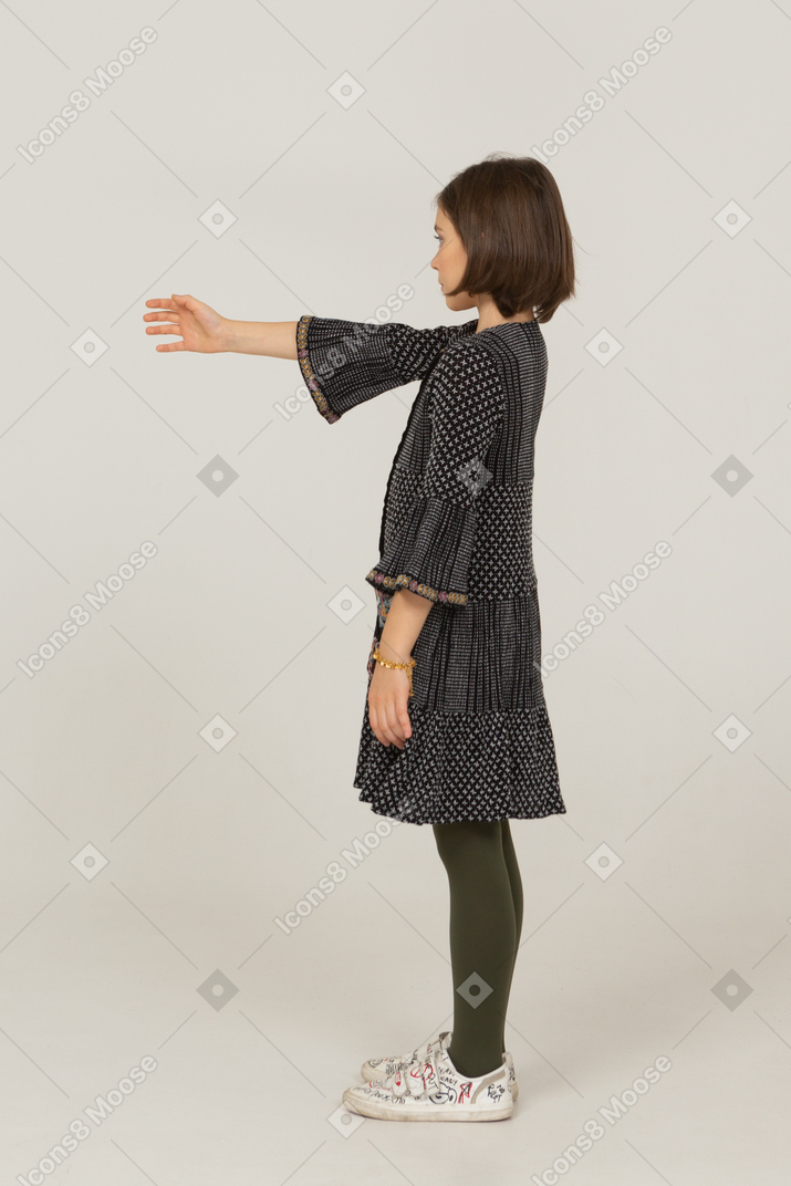 Side view of a little girl in dress outstretching her hand
