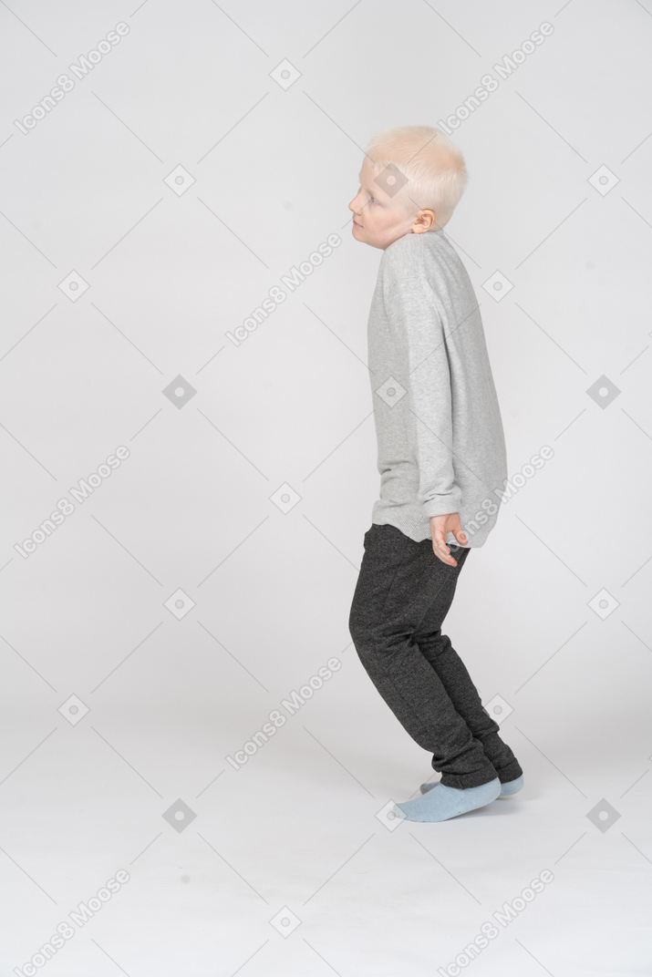 Little boy bending his head and legs