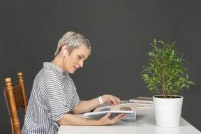 Mujer leyendo una revista en una mesa