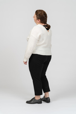 Plump woman in casual clothes standing in profile