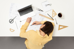 Una mujer arquitecta durmiendo en la mesa