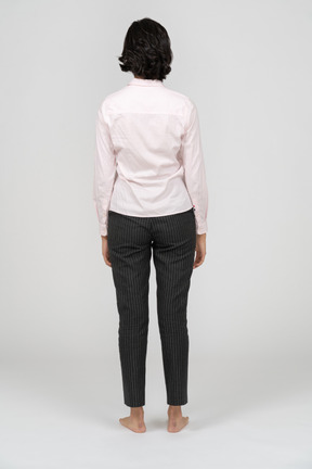 Rear view of a woman in office clothes standing still