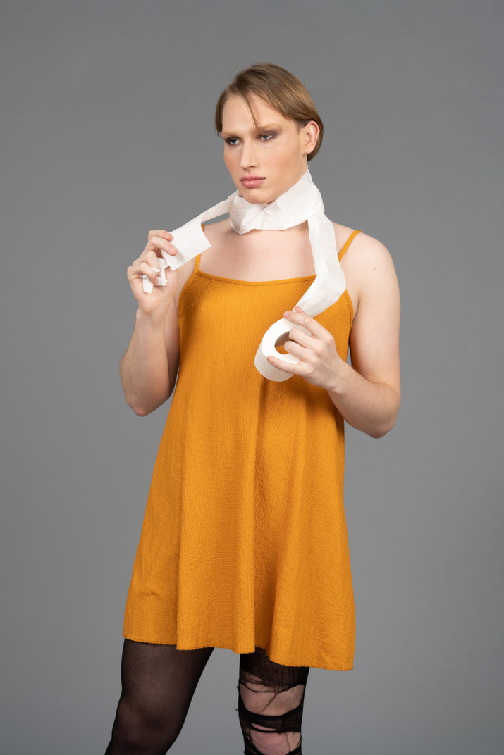 Portrait of a transgender person in orange dress with toilet paper wrapped around neck