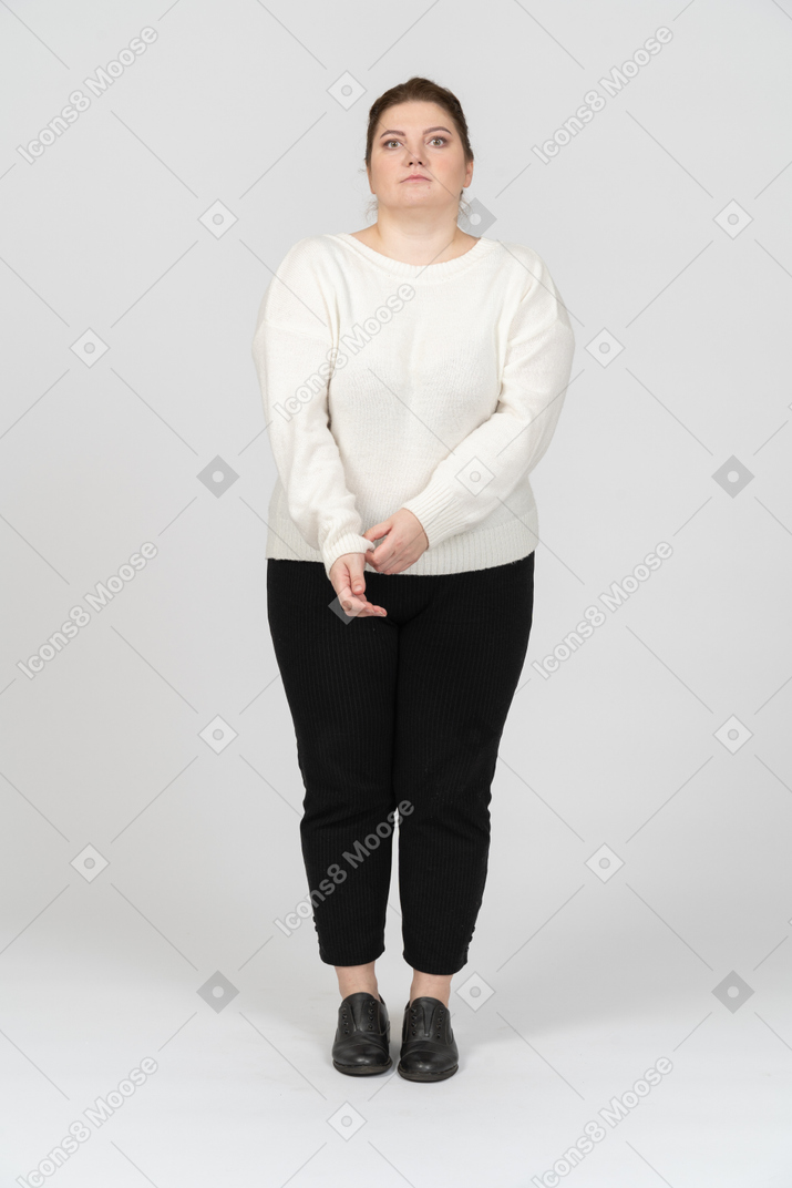 彼女の袖を巻き上げるカジュアルな服を着たプラスサイズの女性の正面図