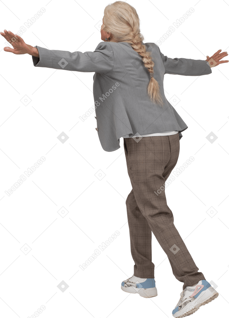 Vista trasera de una anciana en traje de equilibrio sobre una pierna y estirando los brazos