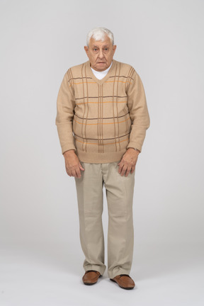 Vista frontal de um velho em roupas casuais, olhando para a câmera