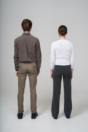 Back view of an unrecognizable young couple in office clothing standing still