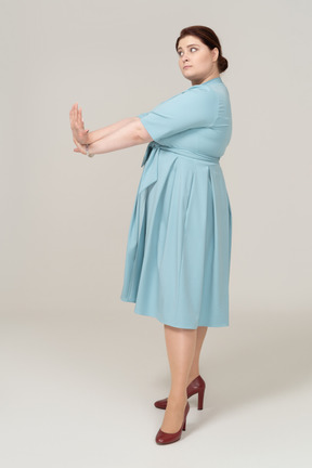 青いドレスを身振りで示す女性の側面図