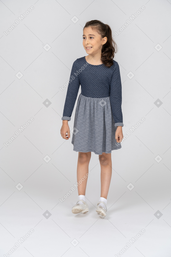 Front view of a girl standing on her heels funnily and laughing