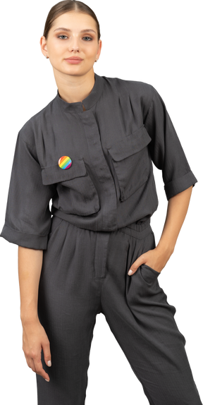 Front view of a young woman in a jumpsuit with lgbt pin