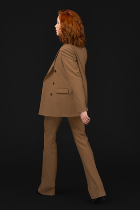 A woman with red hair wearing a tan suit