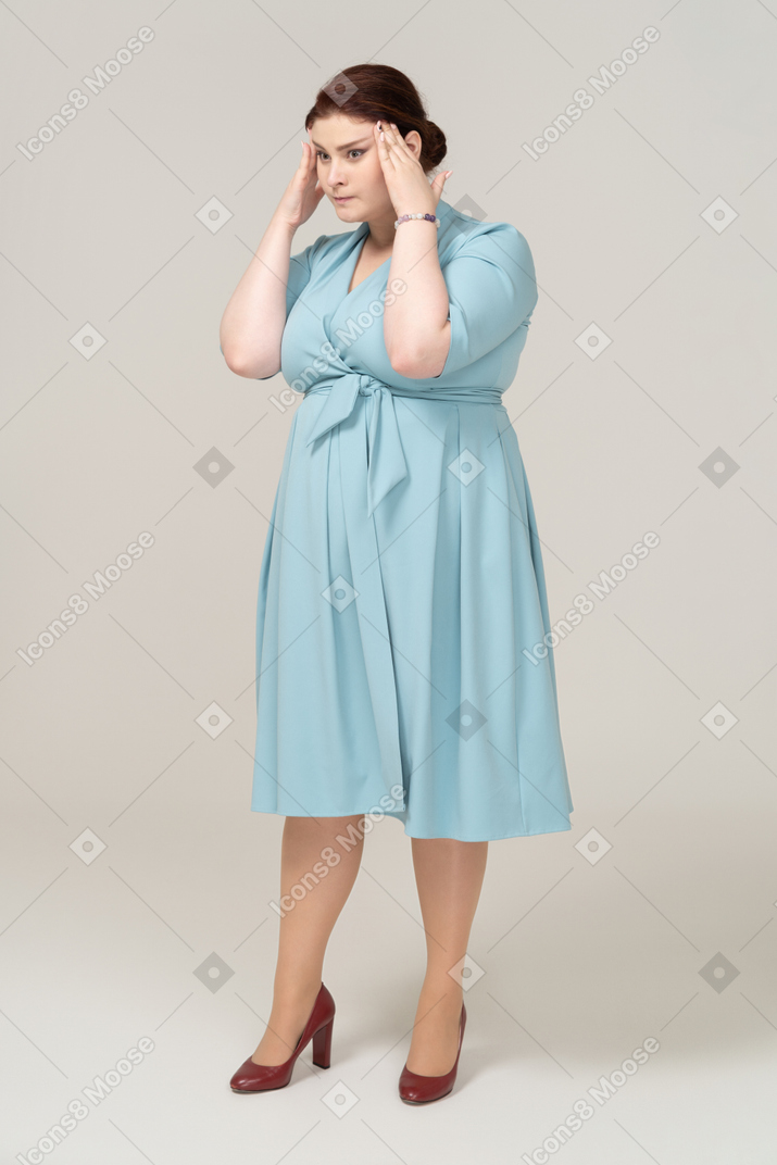 一个穿蓝色连衣裙的女人摸头的前视图