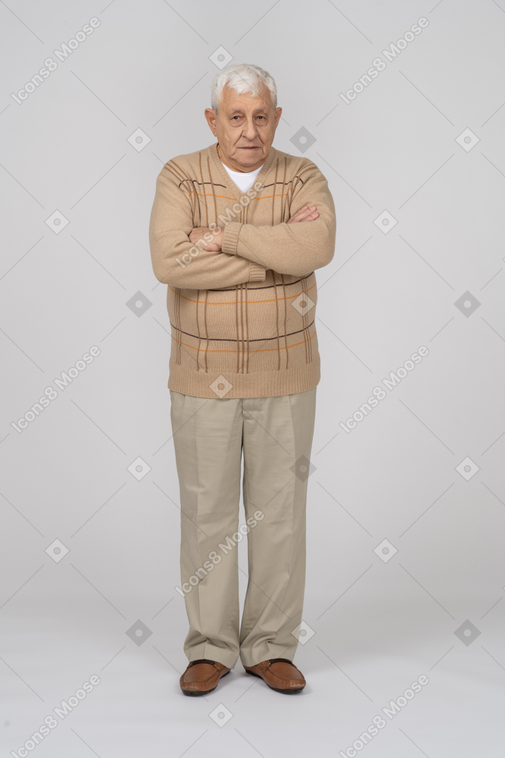 腕を組んで立っているカジュアルな服装の老人の正面図