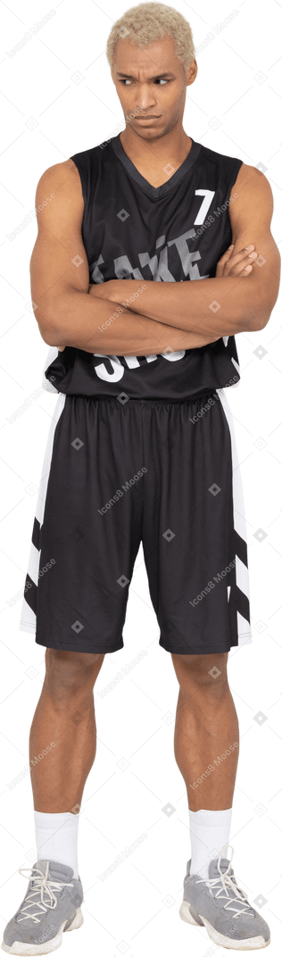 一个内向的年轻男篮球运动员交叉双臂的前视图