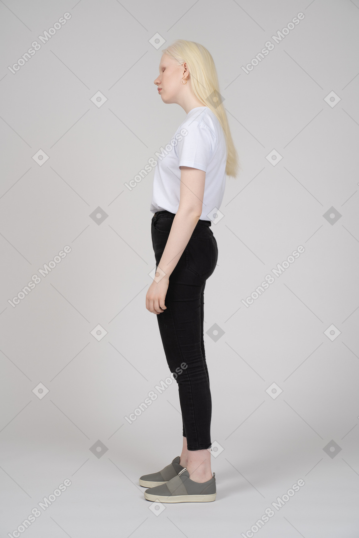 Vue latérale d'une jeune femme en vêtements décontractés regardant vers le bas