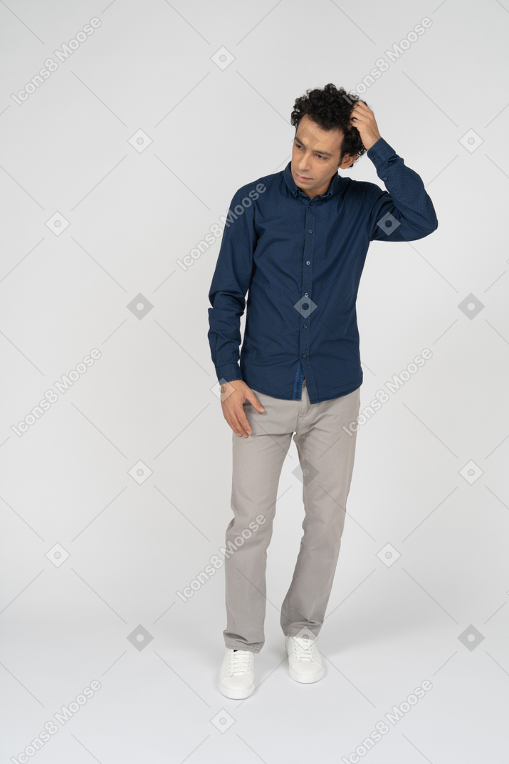 Front view of a man in casual clothes touching head