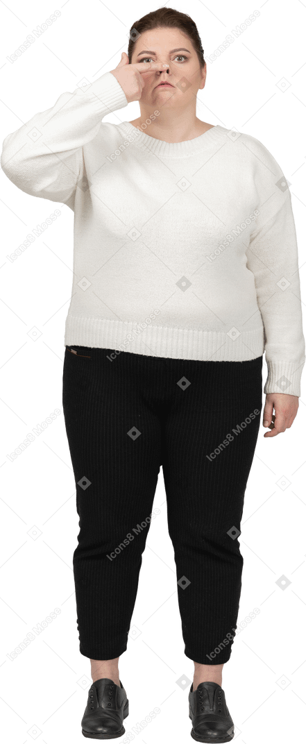 Plump woman in casual clothes touching nose