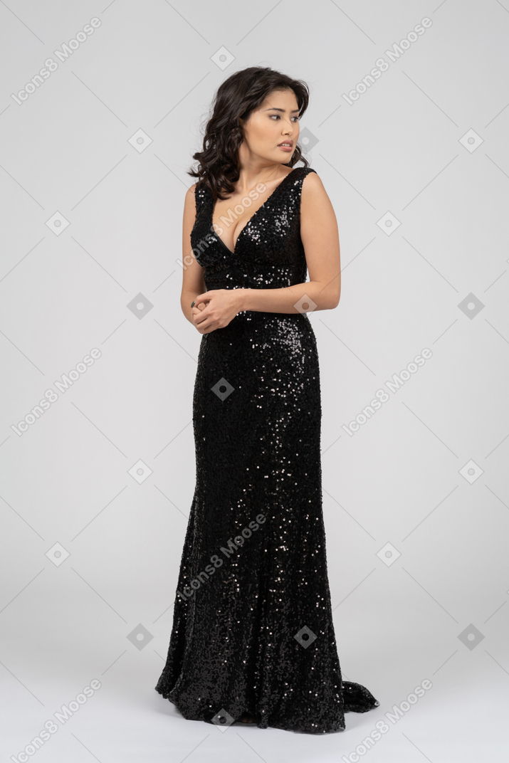 Женщина в черном вечернем платье разворачивается