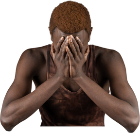 Vorderansicht eines zurückgezogenen jungen afro-mannes, der in der nähe von fleisch sitzt