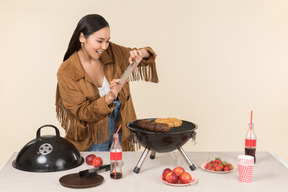 Joven asiática que tiene problemas con la barbacoa