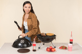 Junge asiatische frau macht einen grill