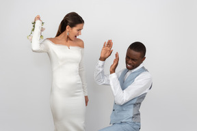 Bride is going to punch her groom with the bouquet