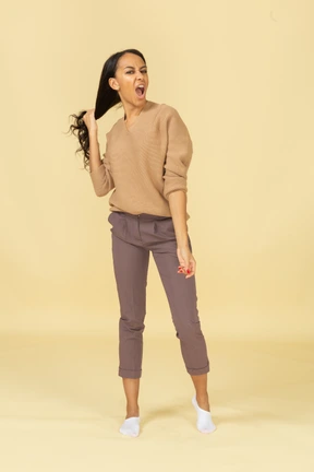 抓住她的头发的黝黑尖叫年轻女士的前视图