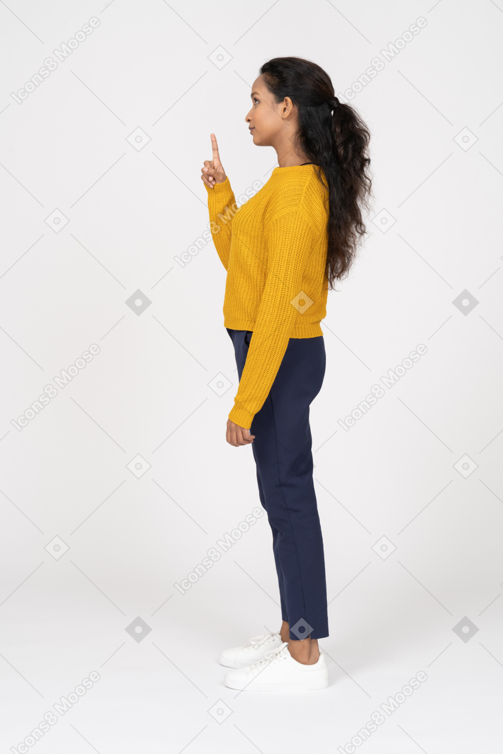 Vista laterale di una ragazza in abiti casual che indica con un dito