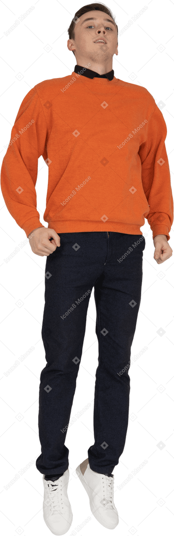 Jeune homme en sweat-shirt orange sautant