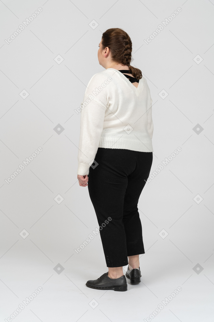 立っている白いセーターのプラスのサイズの女性