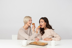 Mujeres jóvenes alimentándose con galletas