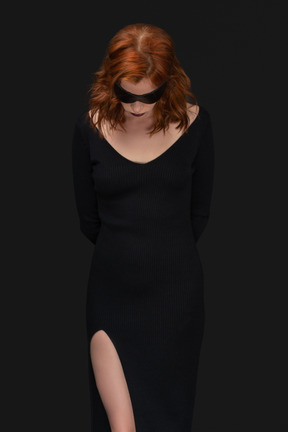 A frontal view of the sexy woman dressed in black with the sleep mask