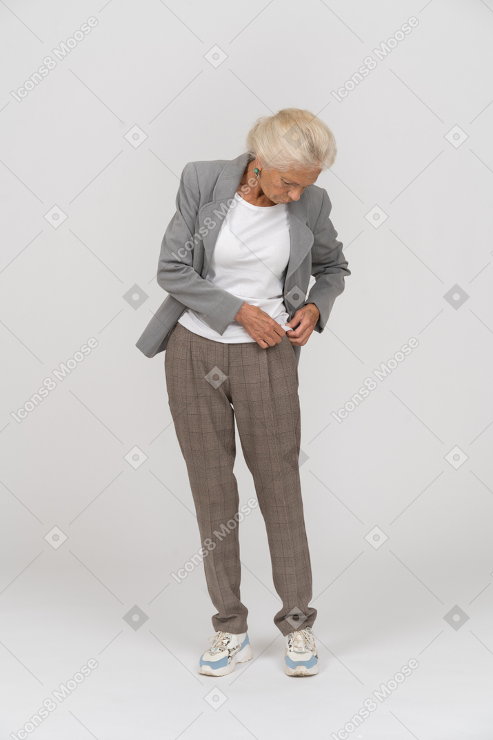 Vista frontal de uma senhora idosa de terno olhando para baixo