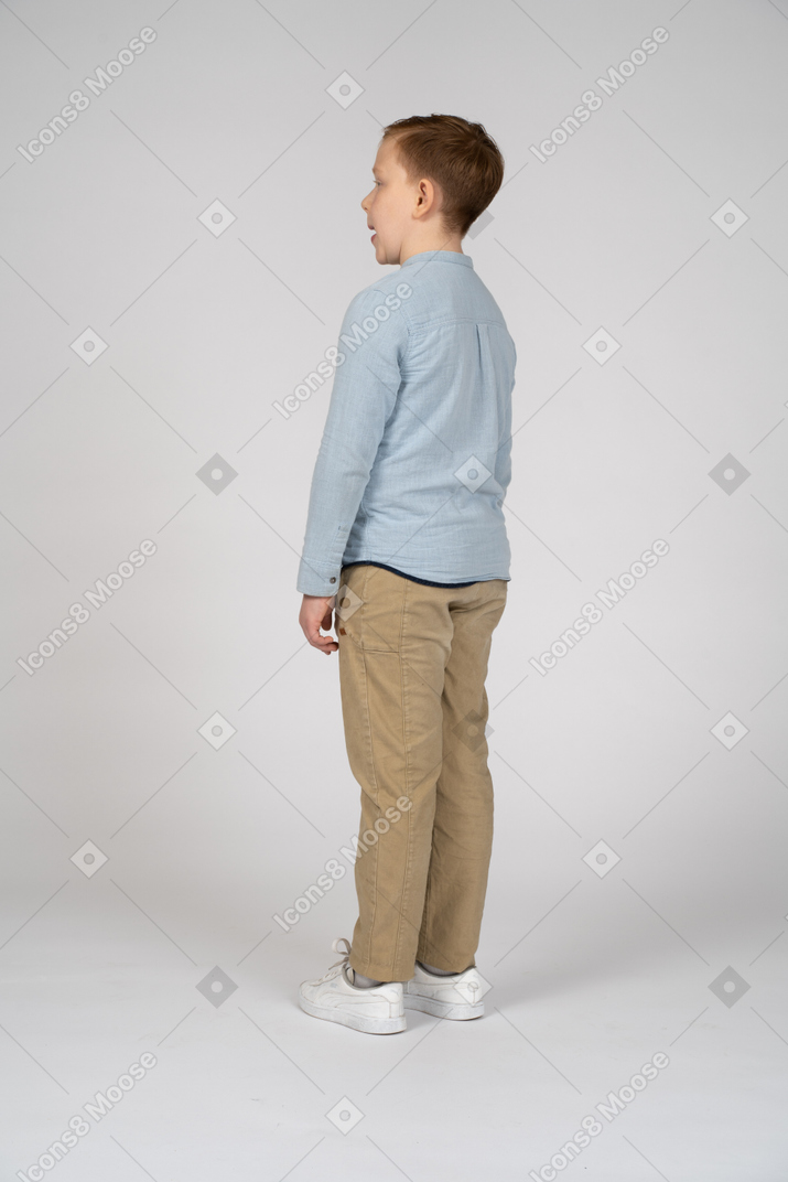 Вид сбоку на мальчика в повседневной одежде, облизывающего губы