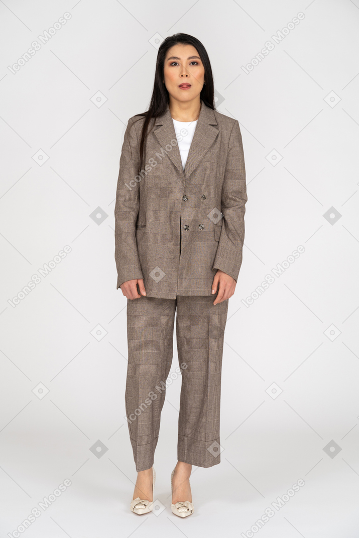 Front view of a young lady in brown business suit showing little tongue