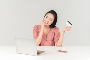 Smiling young asian woman doing online shopping