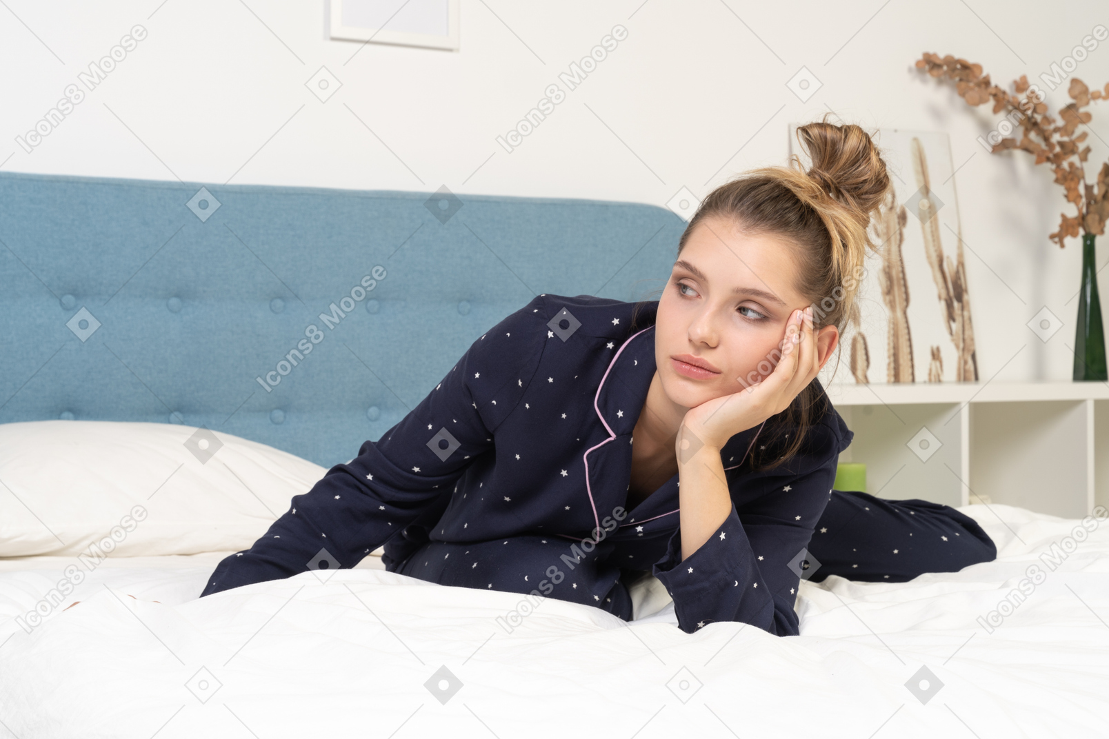 Vorderansicht einer gelangweilten jungen dame im schlafanzug, die im bett bleibt