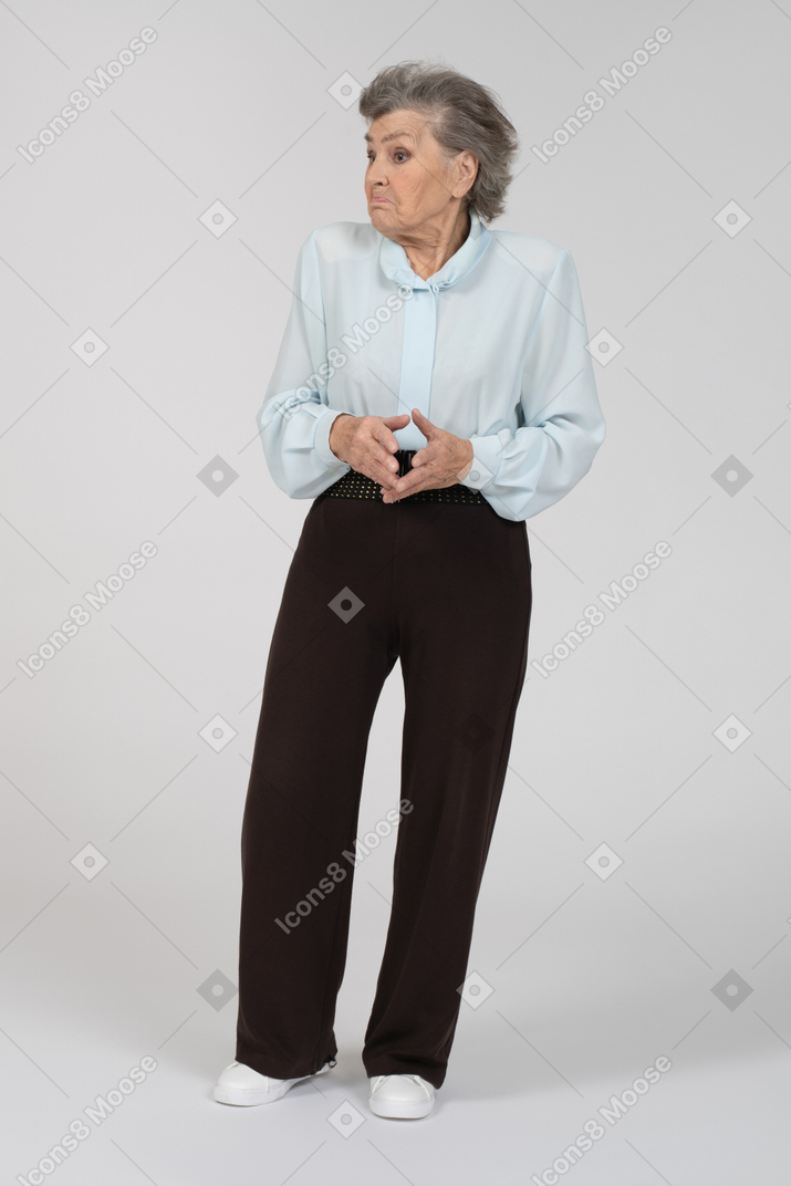 Вид спереди пожилой женщины, пожимающей плечами