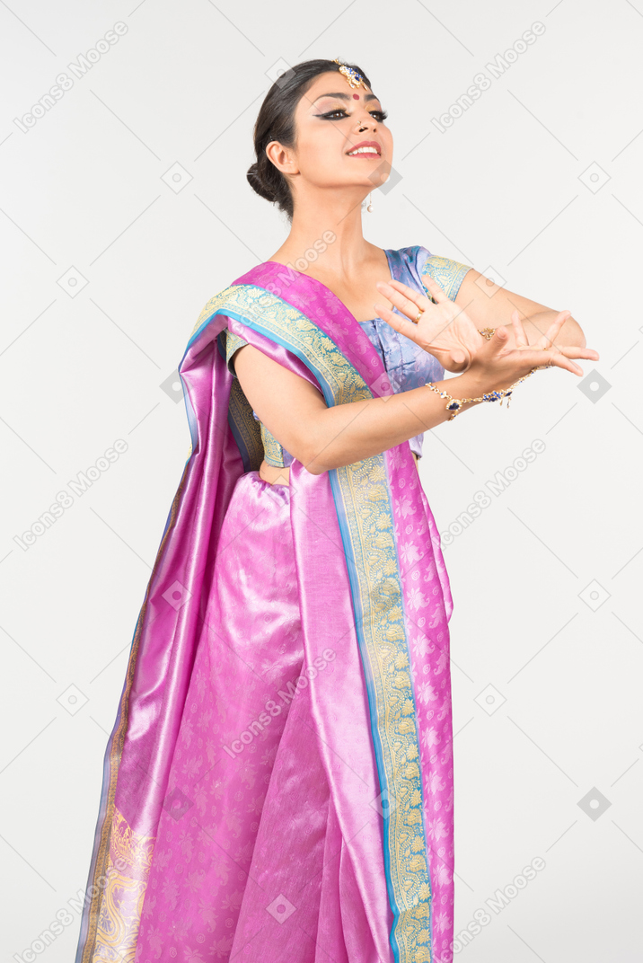 Giovane donna indiana sembrante elettrizzata in sari viola