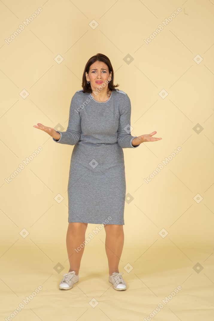 Vista frontal de uma mulher triste em um vestido cinza