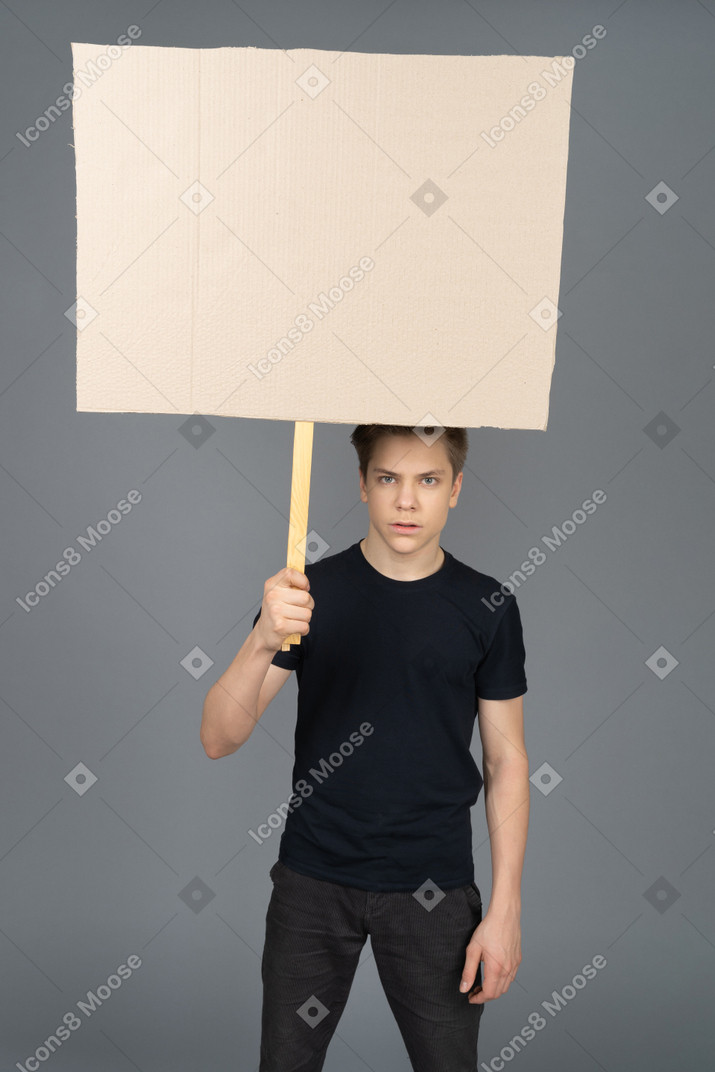 Young man holding a blank poster