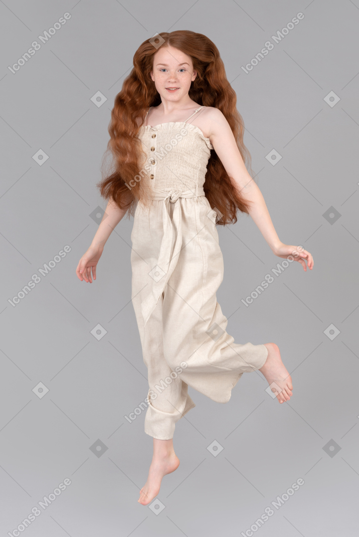Teenage girl with flowing red hair jumping