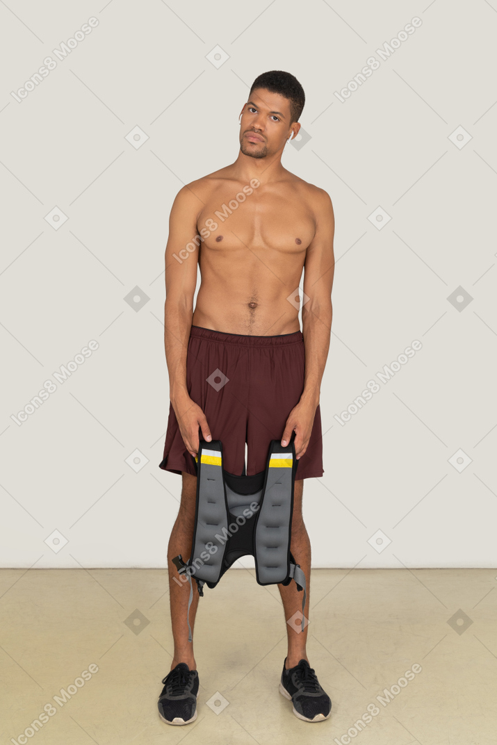 Young man holding weighted vest